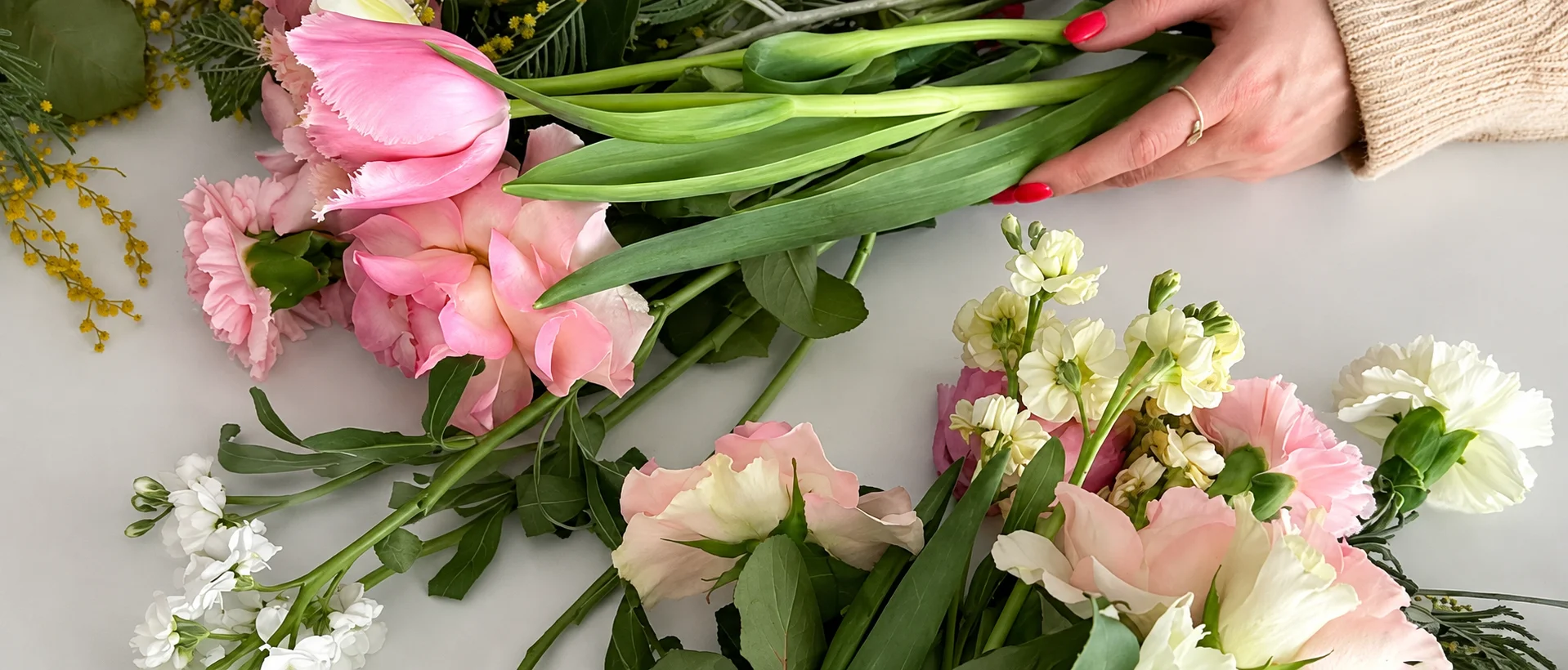 Floriste kārto rozā tulpes, rozes un neļķes